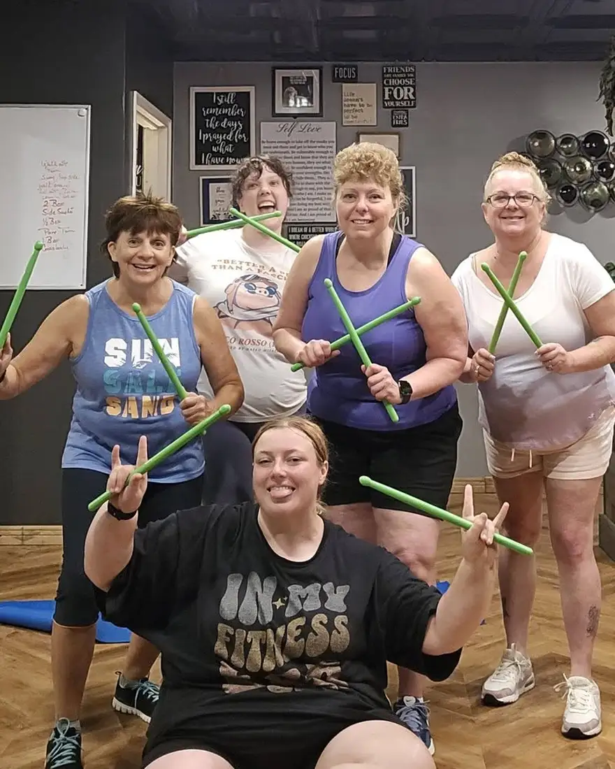 Adults laughing through a high-energy drumstick cardio class at Effervescent Studios in Granite City