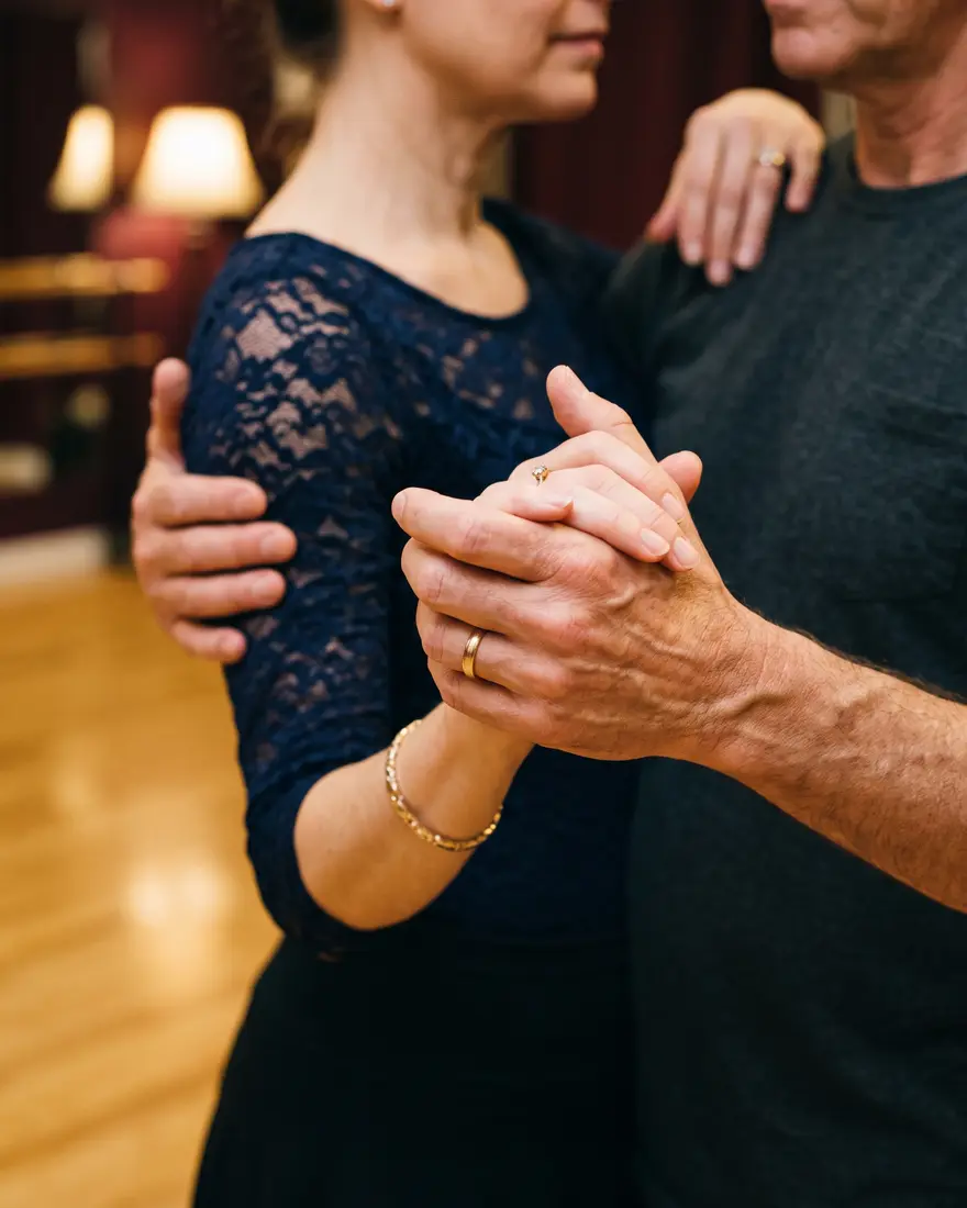 Close view of two adults connected in a ballroom dance hold during a private lesson at Effervescent Studios
